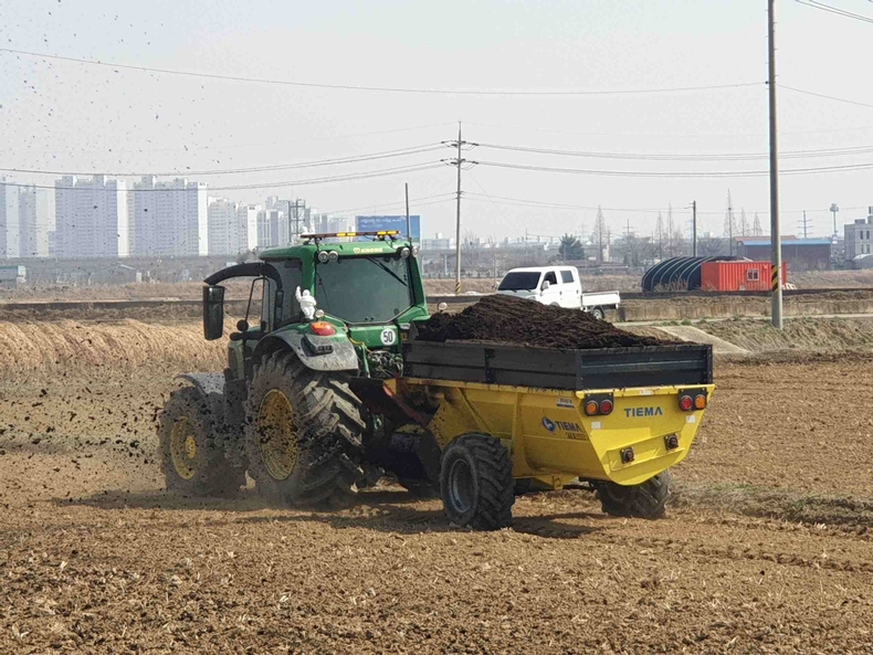 가축분뇨퇴비를 농지에 살포하고 있는 모습.