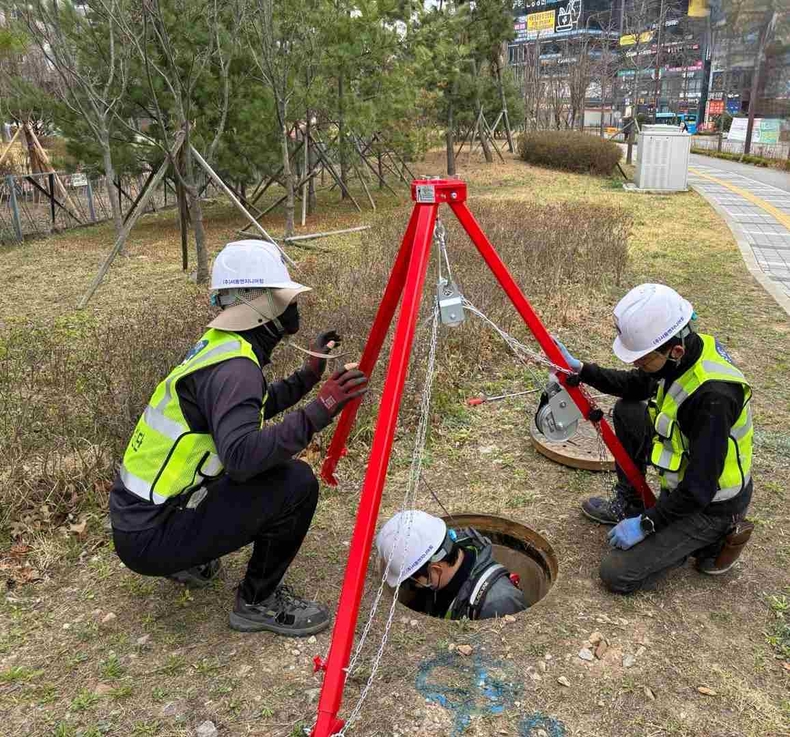 화성특례시 점검반이 추락 방지용 삼각 지지대를 설치하고 대형 상수관 맨홀 내부 점검을 실시하고 있다.