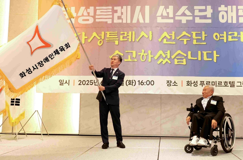 정구원 화성시 제1부시장이 선수단 해단식에서 선수단 기를 흔들고 있다.