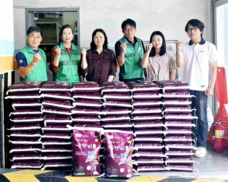 화성시 비봉면새마을협의회가 비봉면행정복지센터에서 바자회 수익금으로 마련한쌀(수향미 10kg) 80포를 전달하고 기념촬영을 하고 있다. 