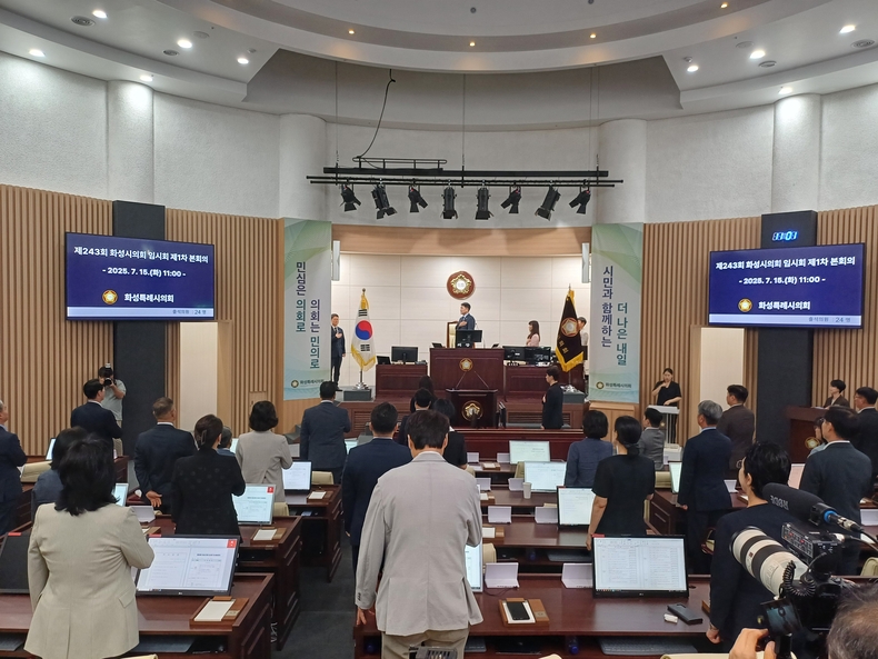 화성시의회가 15일 제243회 임시회를 개회 후 의정활동 주요 성과 발표에 앞서 국민의례를 하고 있다. (사진=정일수 기자)