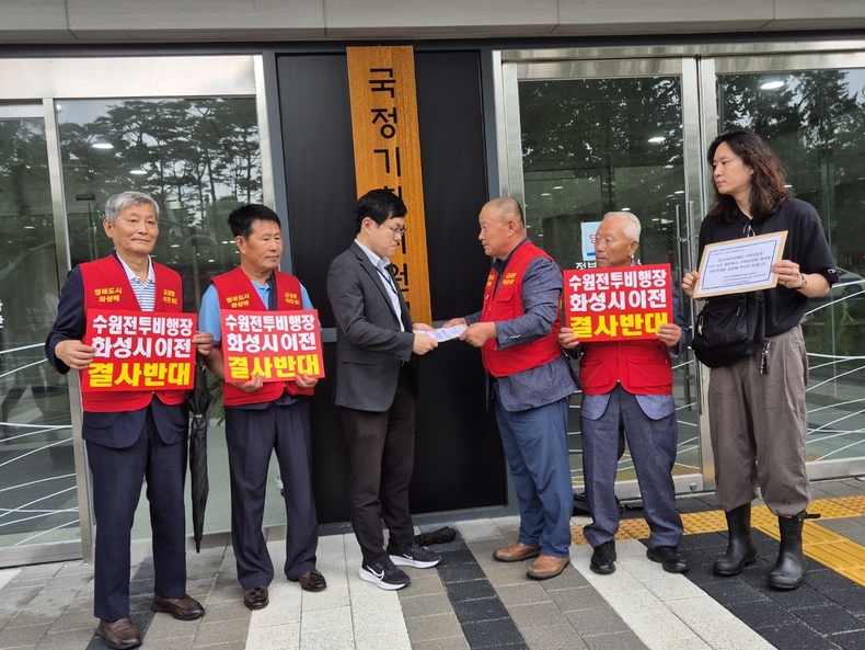 수원전투비행장 화성이전 반대 범시민대책위원회 이상환 상임위원장이 18일 수원군공항이전 TF 및 6자협의체 구성 건의 반대 입장 결의문을 발표하고 반대의견서를 국정기획위원회 관계자에게 전달하고 있다.