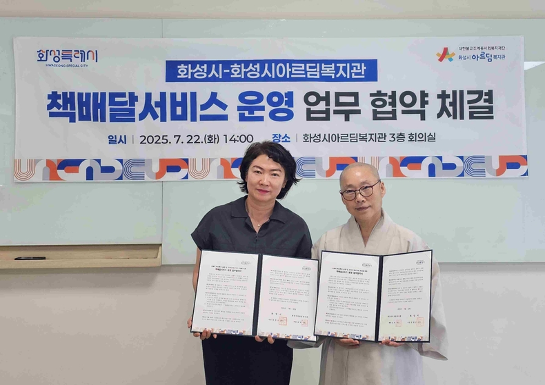 윤미영 화성특례시 도서관정책과장(사진 왼쪽)과 화성시아르딤복지관장 도선스님이 22일 책배달서비스 운영을 위한 업무협약을 체결하고 기념촬영하고 있다.