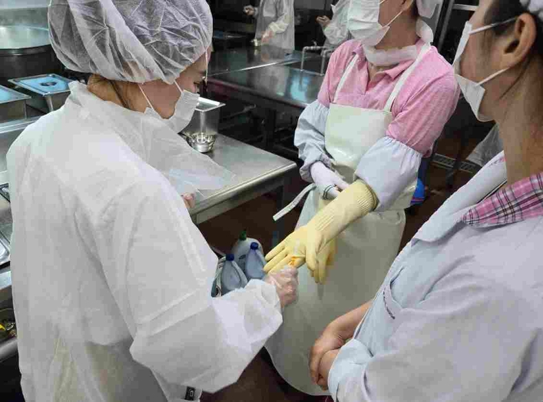 화성특례시 관계자가 동탄라온유치원 급식실에서 진행된 _식중독 발생 대응 모의훈련_에서 조리종사원의 손세균을 측정하고 있다.