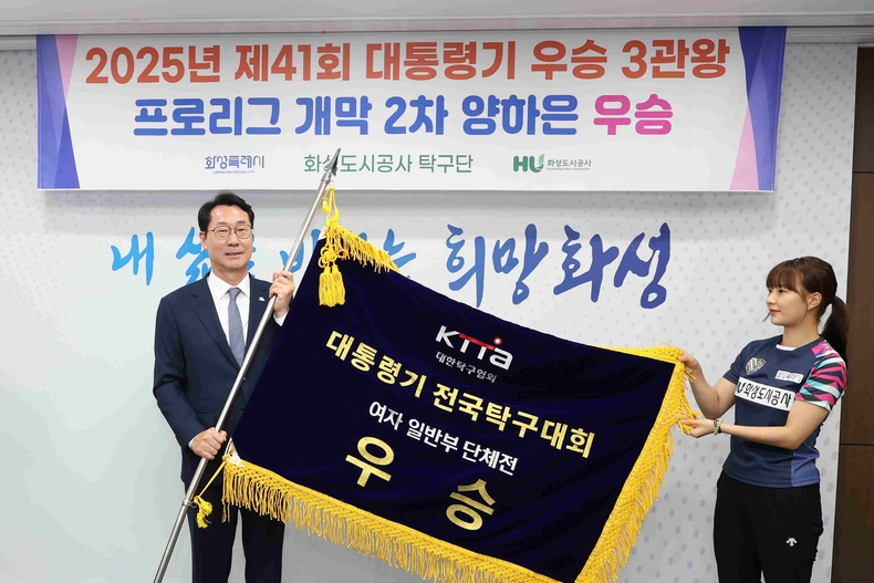 정명근 화성특례시장이 화성도시공사 탁구단으로부터 우승기를 전달받고 있다.
