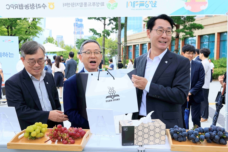 정명근 화성특례시장(사진 오른쪽 첫번째)이 4일 국회 로컬푸드 직거래 장터에서 송산포도를 살펴보며 농업 관계자들과 환담을 나누고 있다.
